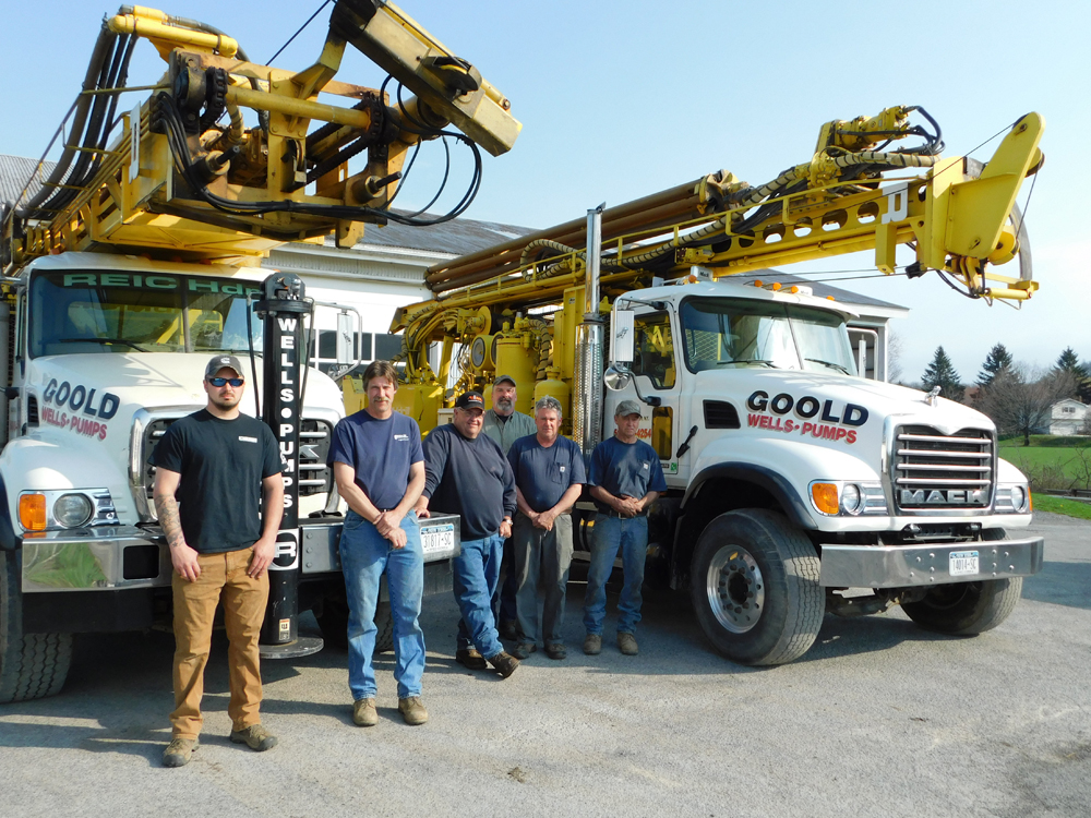 The Goold Wells & Pumps team posing in front of two company trucks