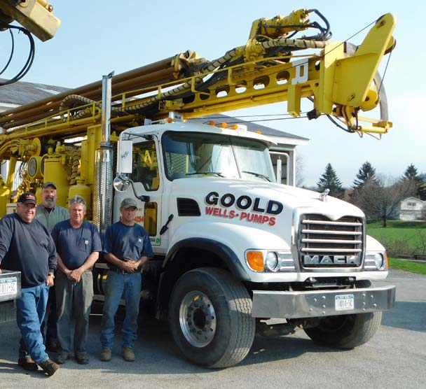 The Goold Wells & Pumps team posing in front of two company trucks