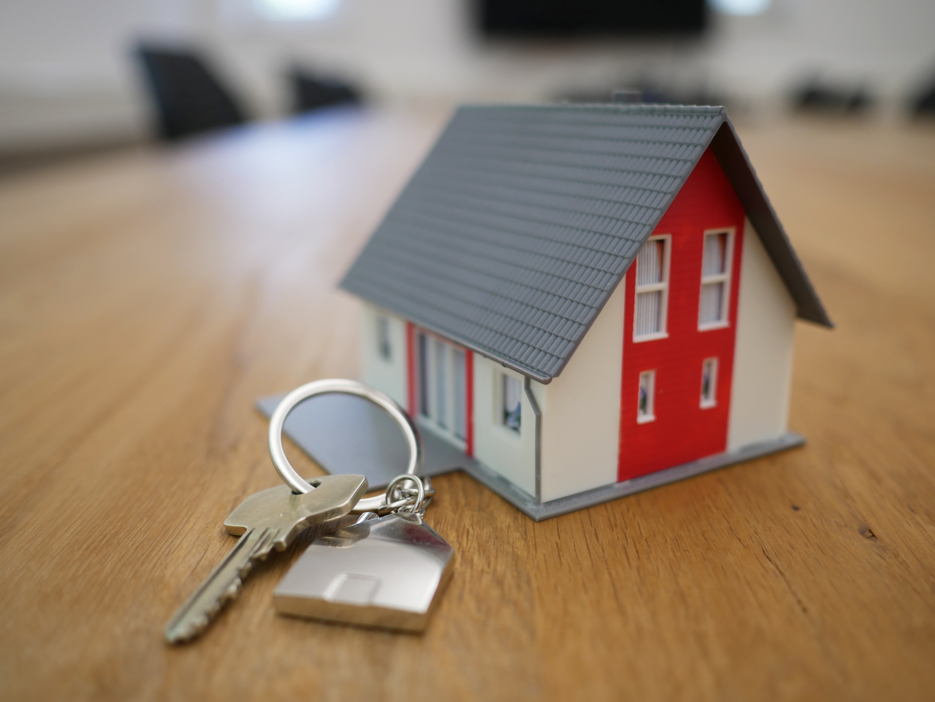 Small model of home on table with house keys